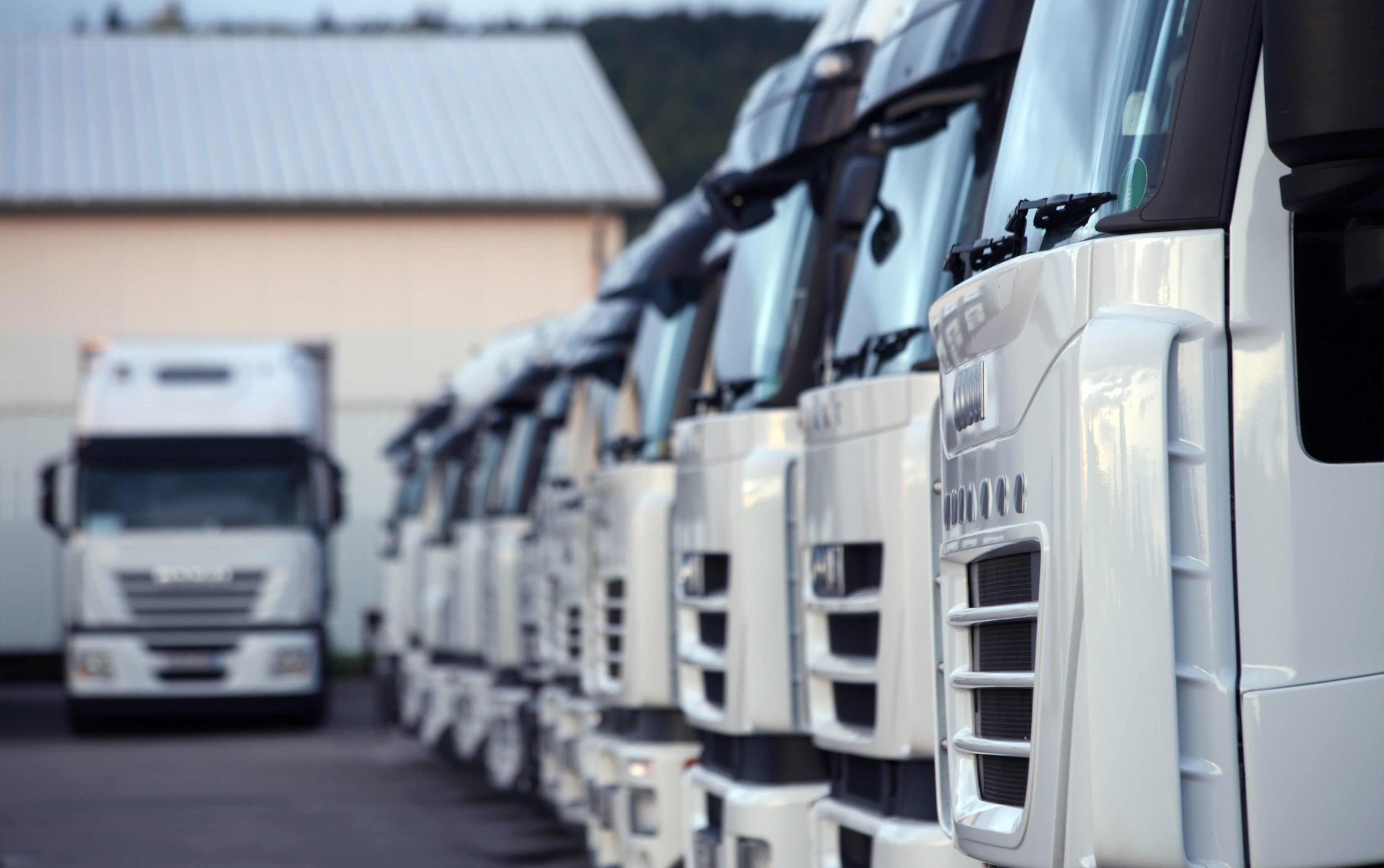 A row of fuel trucks parked in front of a building.
