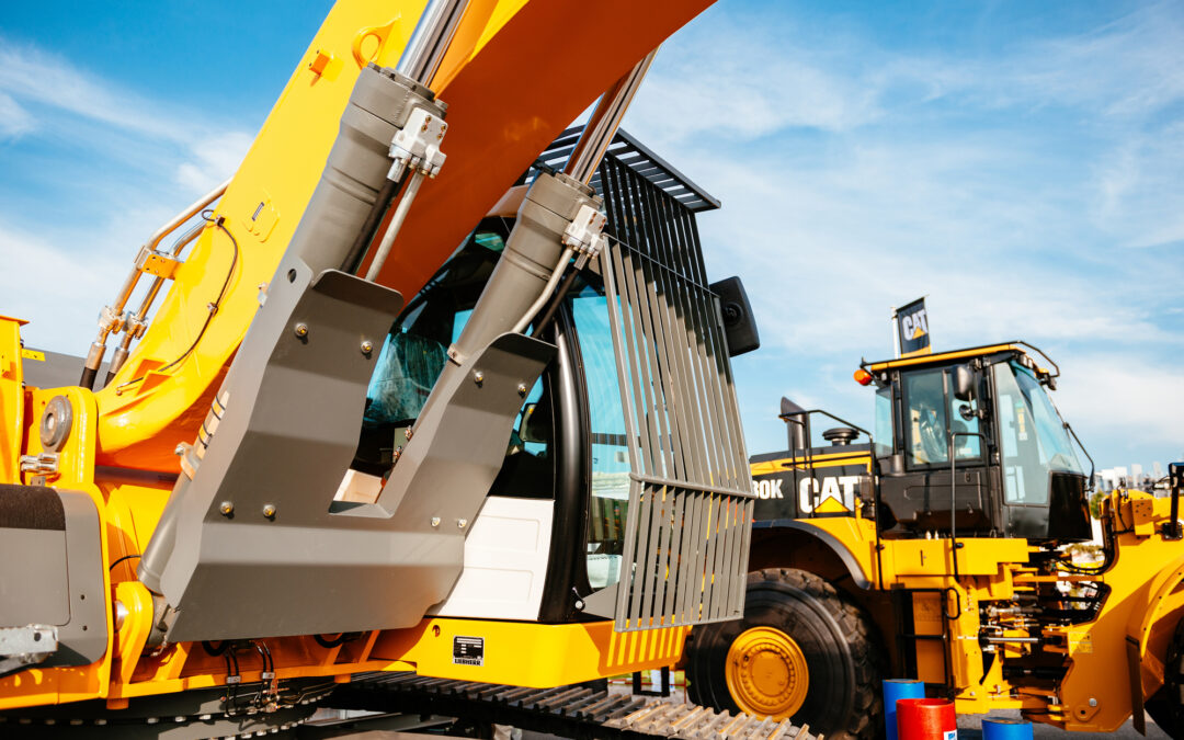 A yellow excavator is parked in a parking lot, responding to Section 2449 within the California Code of Regulations.