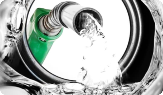 Close-up of a green fuel nozzle dispensing liquid, viewed from inside a vehicle’s fuel tank.